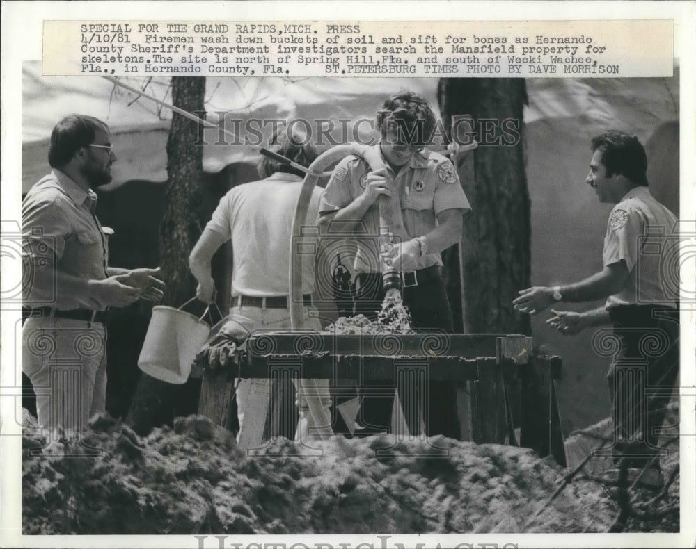 1981 Press Photo Firemen wash down bucket of soil &amp; sift for bones as they - Historic Images