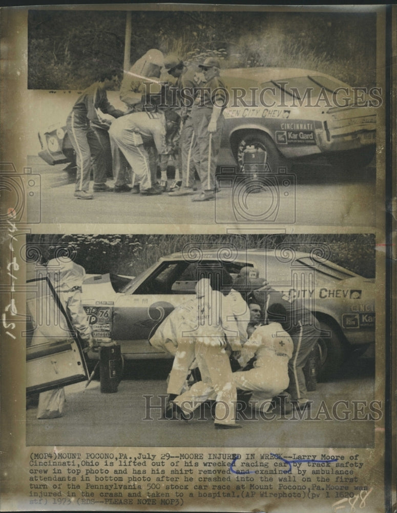 1973 Press Photo Larry Moore lifted out of his wrecked racing car - Historic Images