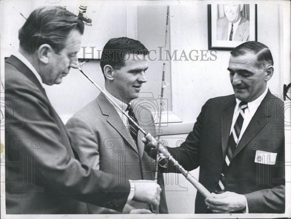 1968 Press Photo Harry Sinden of the Boston Bruins admiring fishing poles - Historic Images