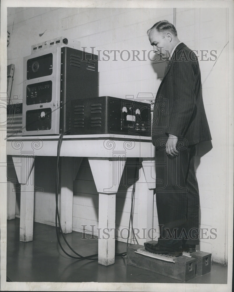 1946 Press Photo Lester Furney steps on the &quot;foot counter&quot; after leaving the lab - Historic Images