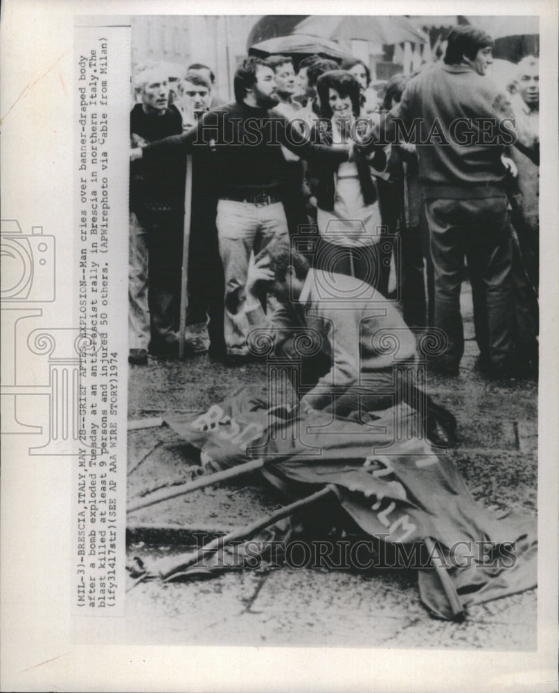 1974 Press Photo Man cries over a body after bomb explodes during protest. - Historic Images