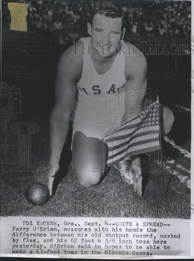 1956 Press Photo Parry O'Brien easures with his hands the difference between hi old shotput record - Historic Images