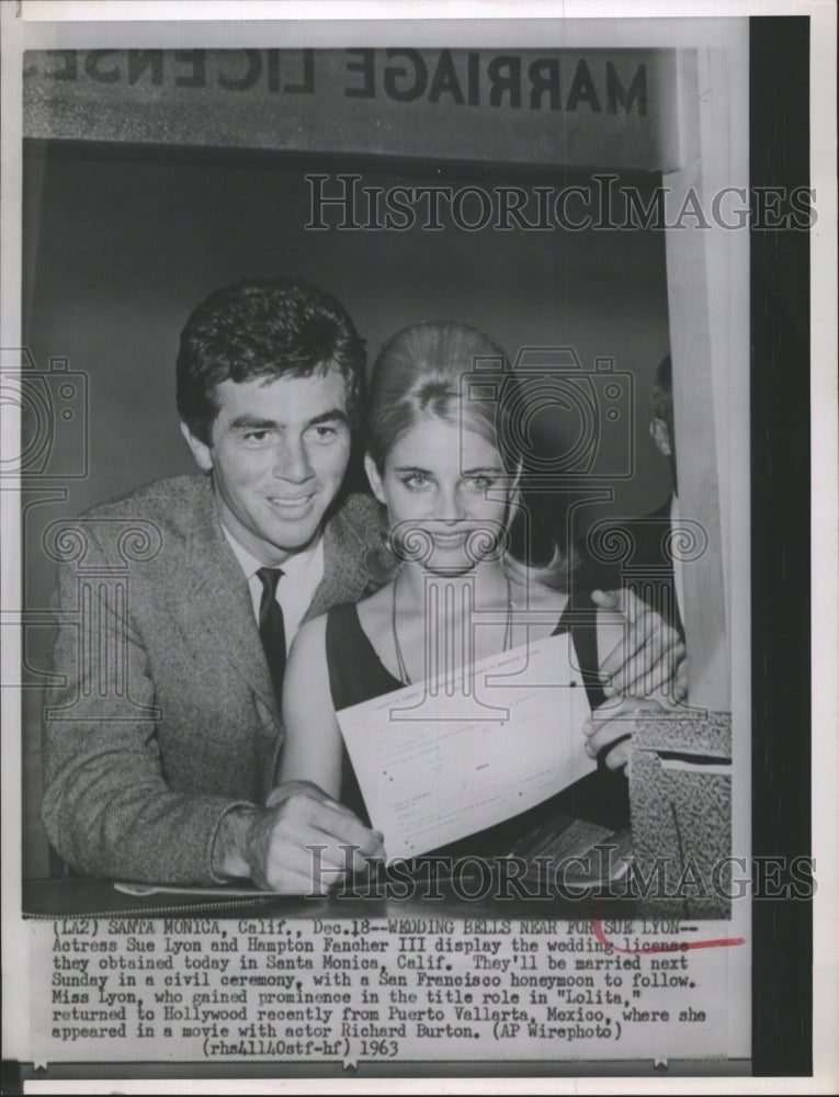 1963 Press Photo Sue Lyon and Hampton Fencher III display wedding license. - Historic Images