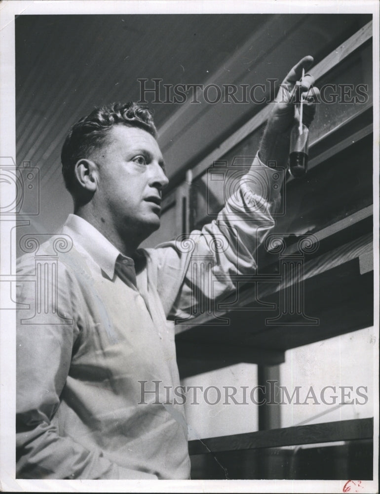 1957 Press Photo Dr. Robert Hutton checking laboratory snails. - RSH39231 - Historic Images