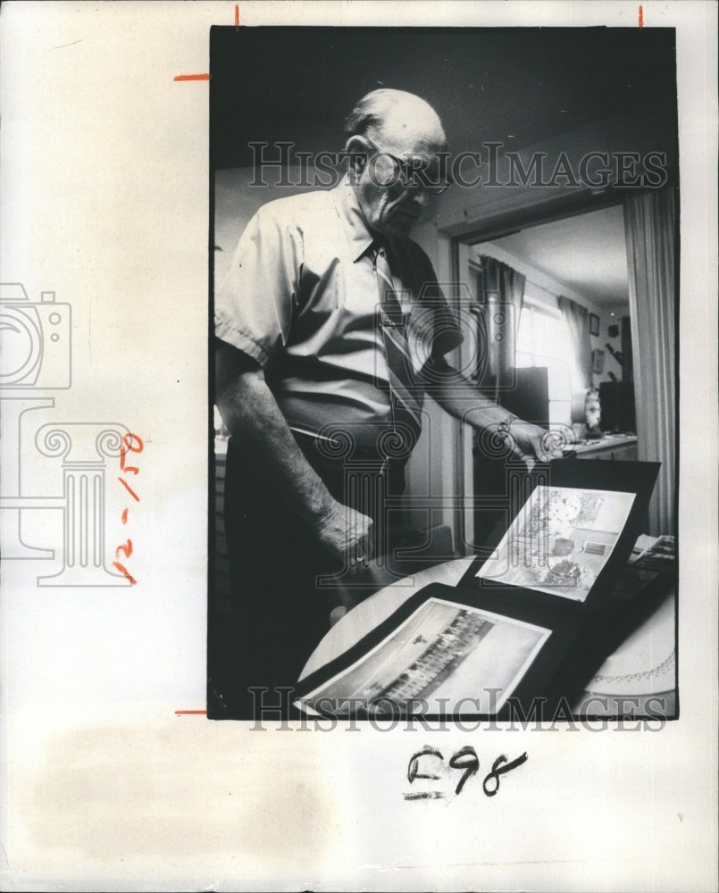 1976 Press Photo A.J. Martin look over scrap book of his World War II Book. - Historic Images