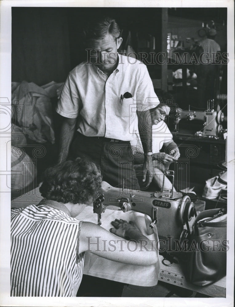 1962 Charlie Morgan watches woman sew - Historic Images