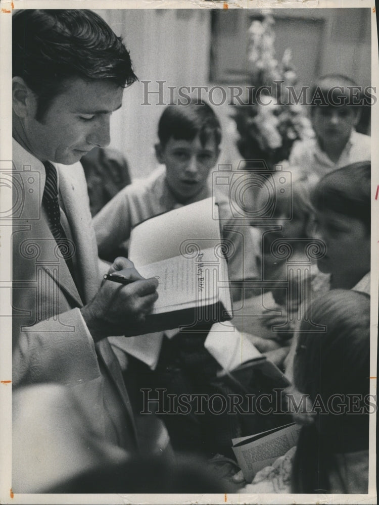 1972 Children watch a man sign the Bible - Historic Images