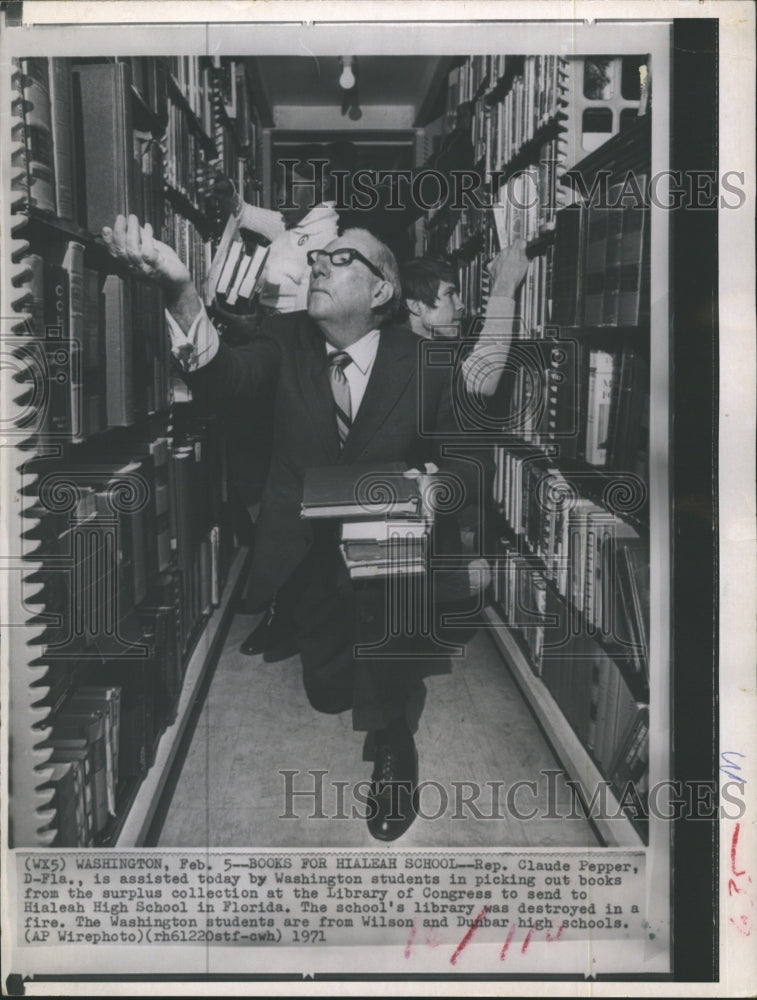 1971 Rep. Claude Pepper selects books for donation. - Historic Images