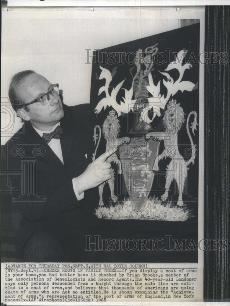 1968 Brian Brooks examining a coat of arms  - Historic Images