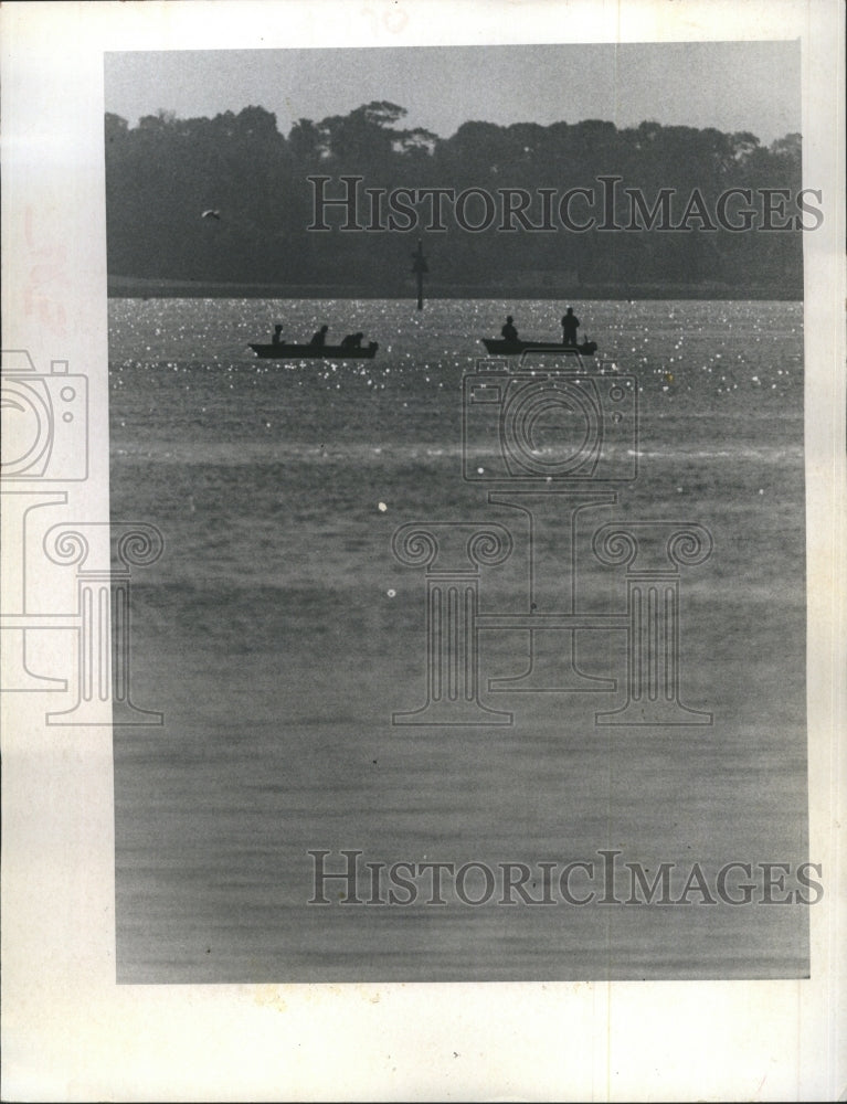 1974 Fisherman silhouette on sparkling Clearwater Bay. - Historic Images