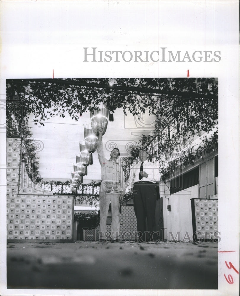 1957 Fair manager J.C. Huskisson watches Chris Kampf decorate - Historic Images