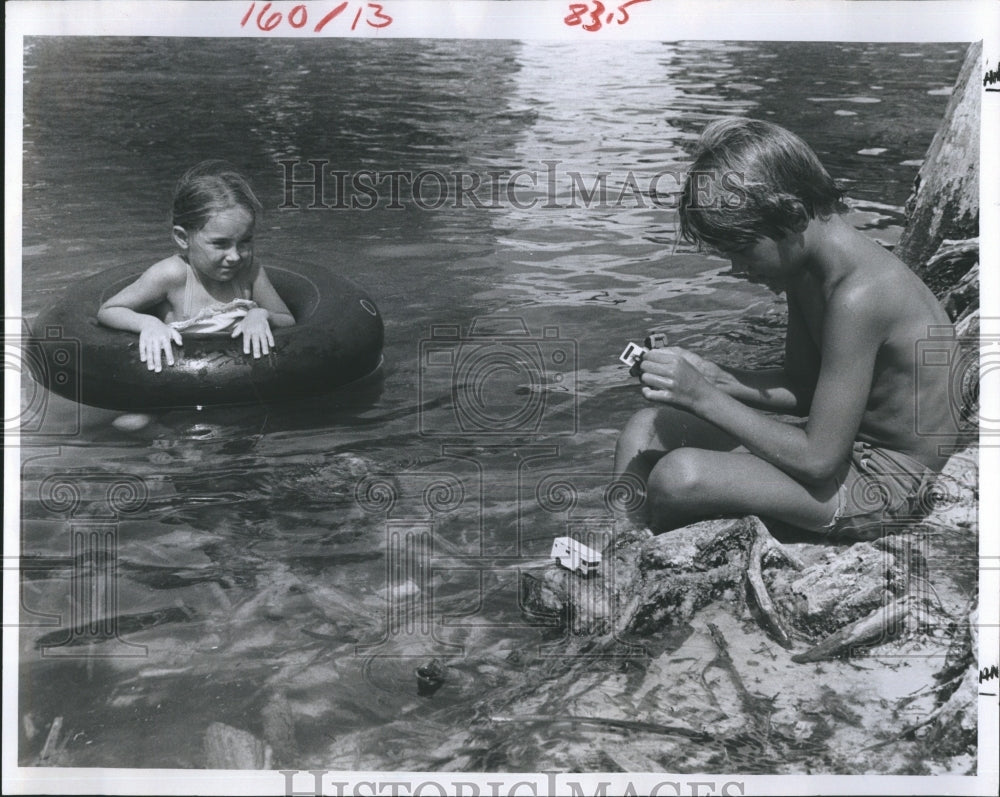 1981 Alicia Hutchinson watches Dean Rasmussen play with his cars - Historic Images