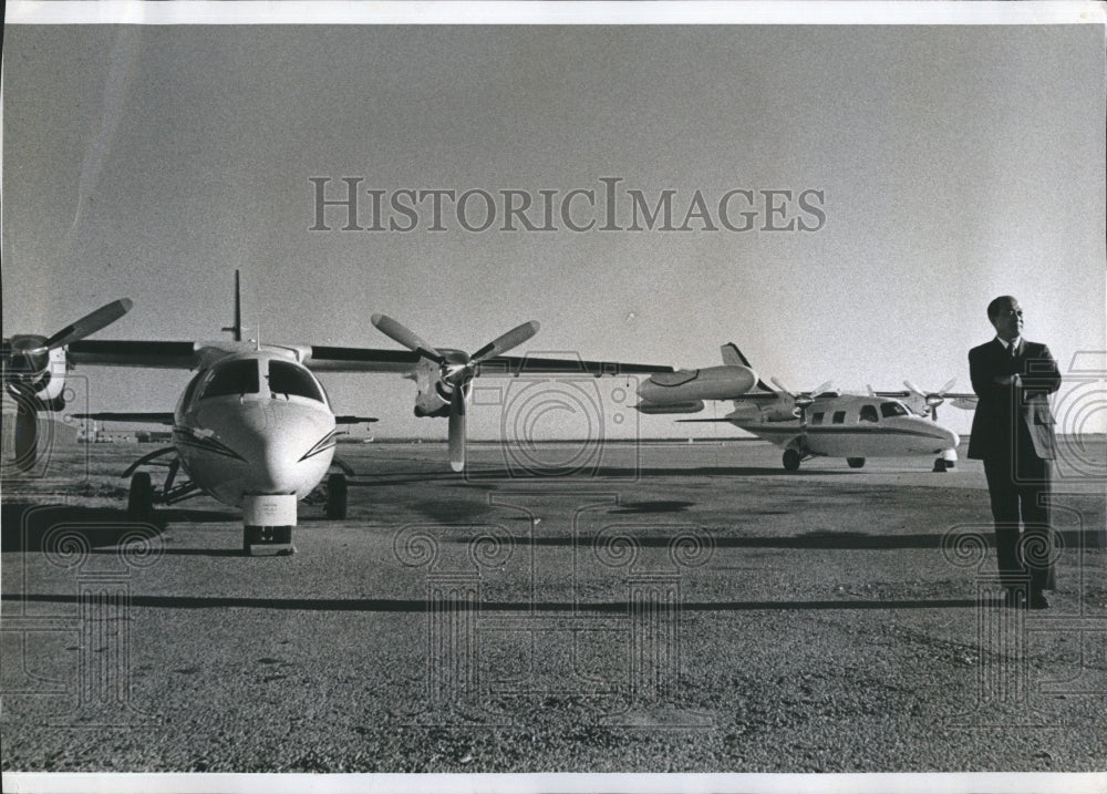 1974 Makoto Kuroiwa,pres of Mitsubishi Aircraft posing with 2 MU - Historic Images