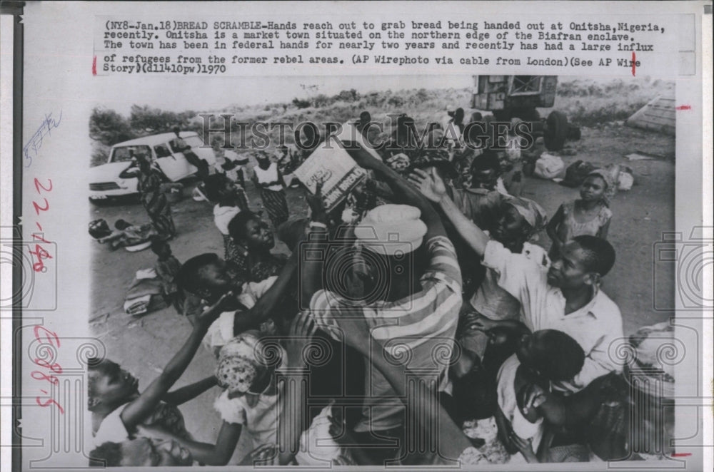 1970 Hands reach out for bread being handed out in Onitsha, Nigeria - Historic Images