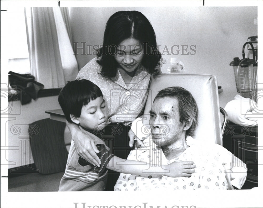 1986 Huong Nguyen, with electrical burns, wife Mylien Dao and son. - Historic Images