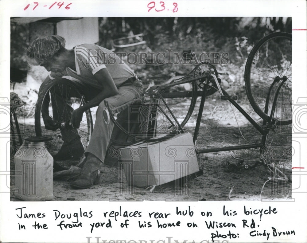 1985 James Douglas repair his bicycle. - Historic Images