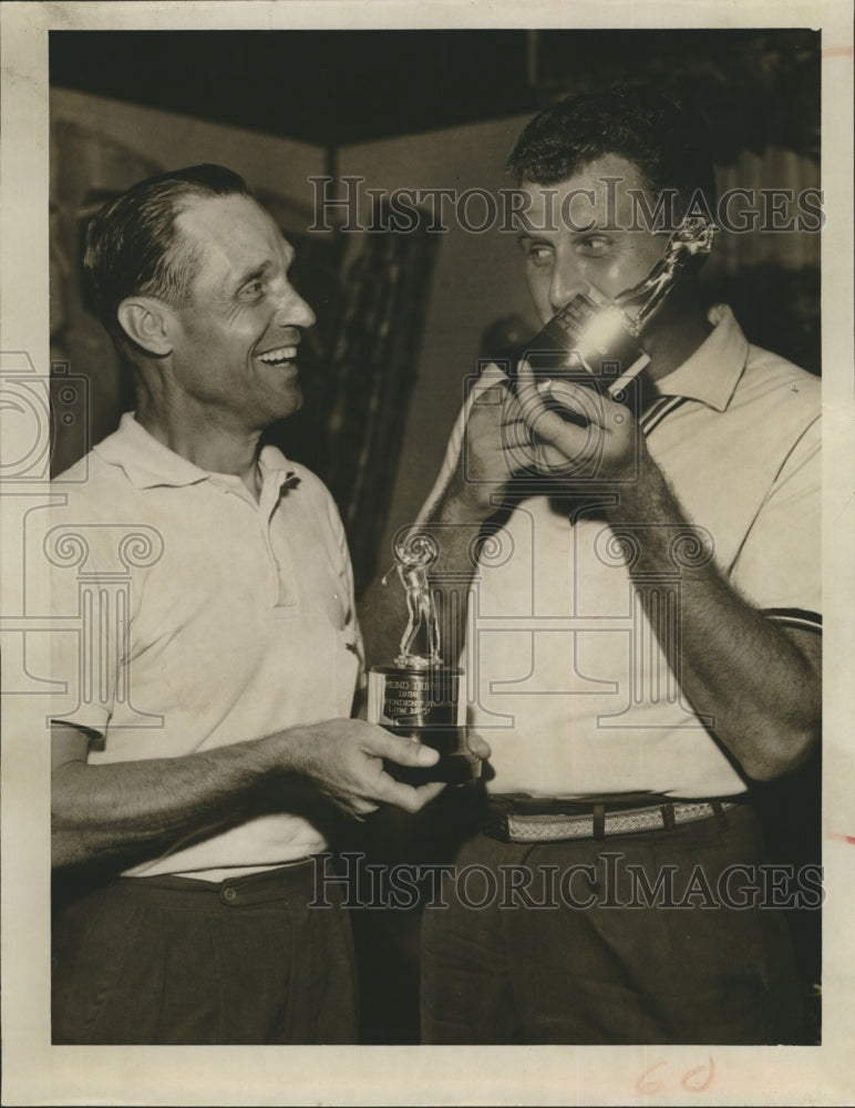 1958 Walt Swihart and Chuck Miller compare golf trophies  - Historic Images