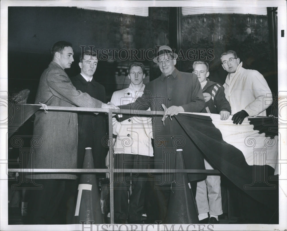 1960 Football rival coaches shakes hands at platform with players. - Historic Images