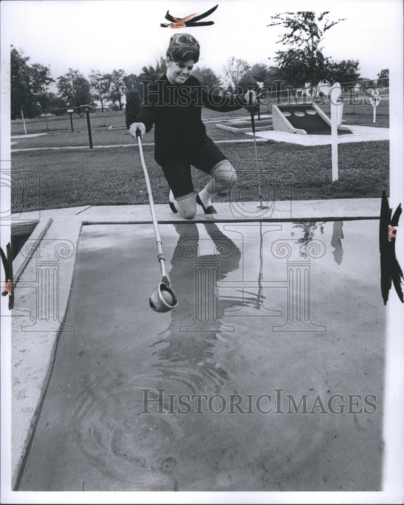 1967 Woman retrieving ball from water at miniature golf course - Historic Images