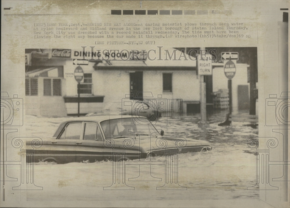 1969 Motorist flows through deep water in New York.  - Historic Images
