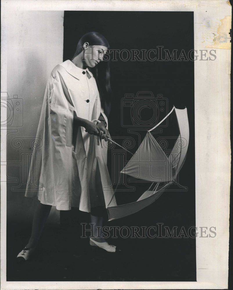 1966 A women modeling vinyl rainwear. - Historic Images