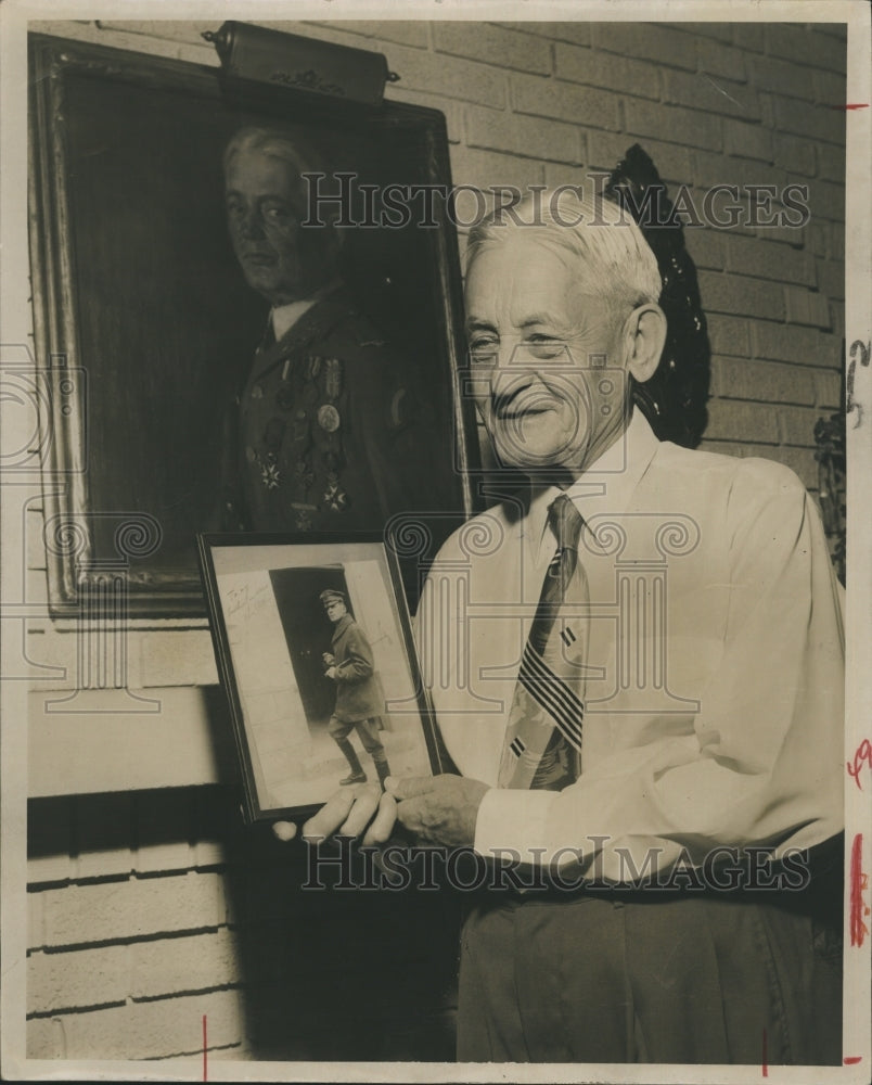 1958 Col. Hughes holds a picture of Gen. Douglas MacArthur - Historic Images