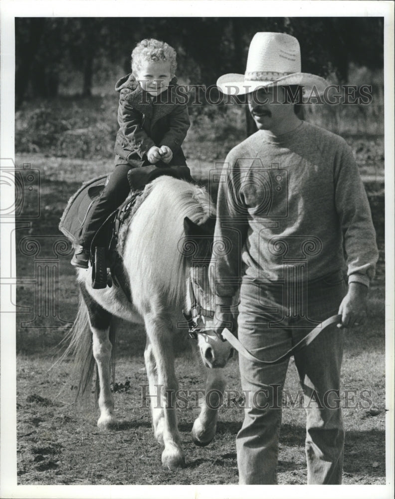 1989 Kindergartner David Walker rides a horse on a class trip to - Historic Images