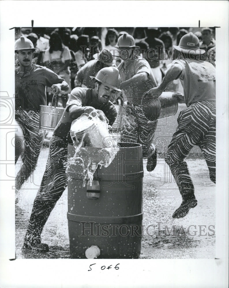 1992 Press Photo Scott Eddinger filling barrel at bucket brigade event - Historic Images