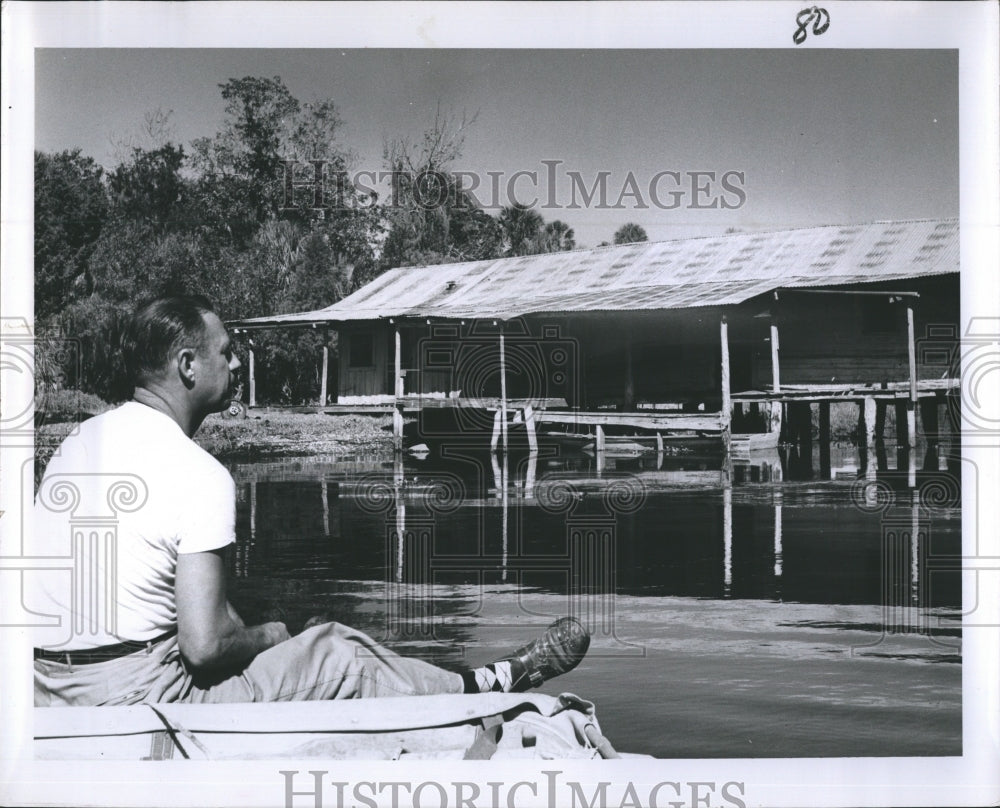 A picture of a river with the man on his boat  - Historic Images