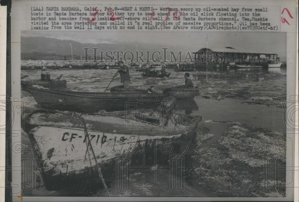 1997 Workmen scoops oil soaked hay from boats in Santa Barbara harbo - Historic Images