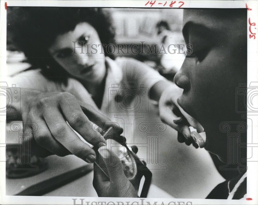 1981 Tony DeCesare checking his teeth with Shelicia Collier - Historic Images