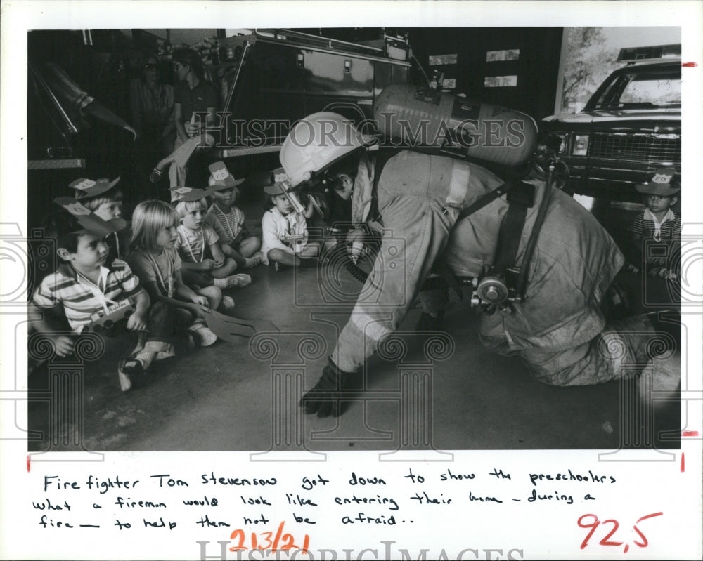 1984 Mike Day get down with the kids to explain fire safety - Historic Images