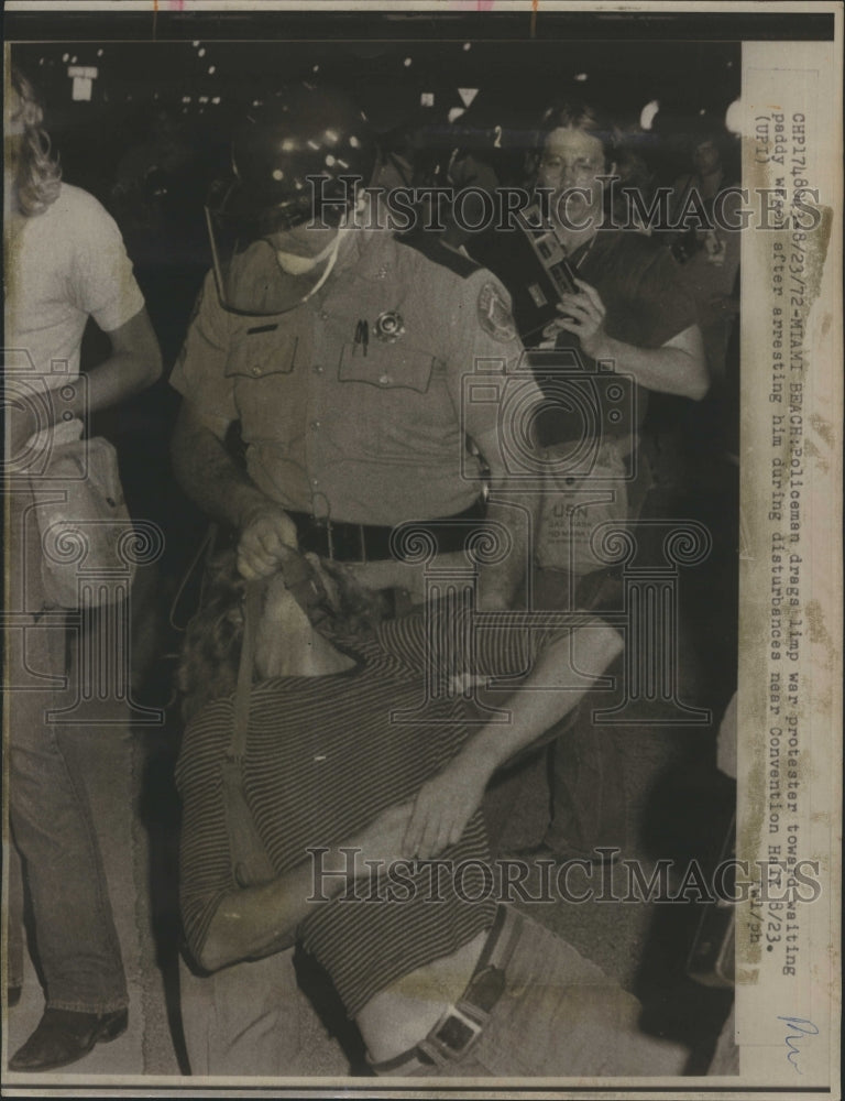 1972 Policeman drags war protestant during republican convention. - Historic Images