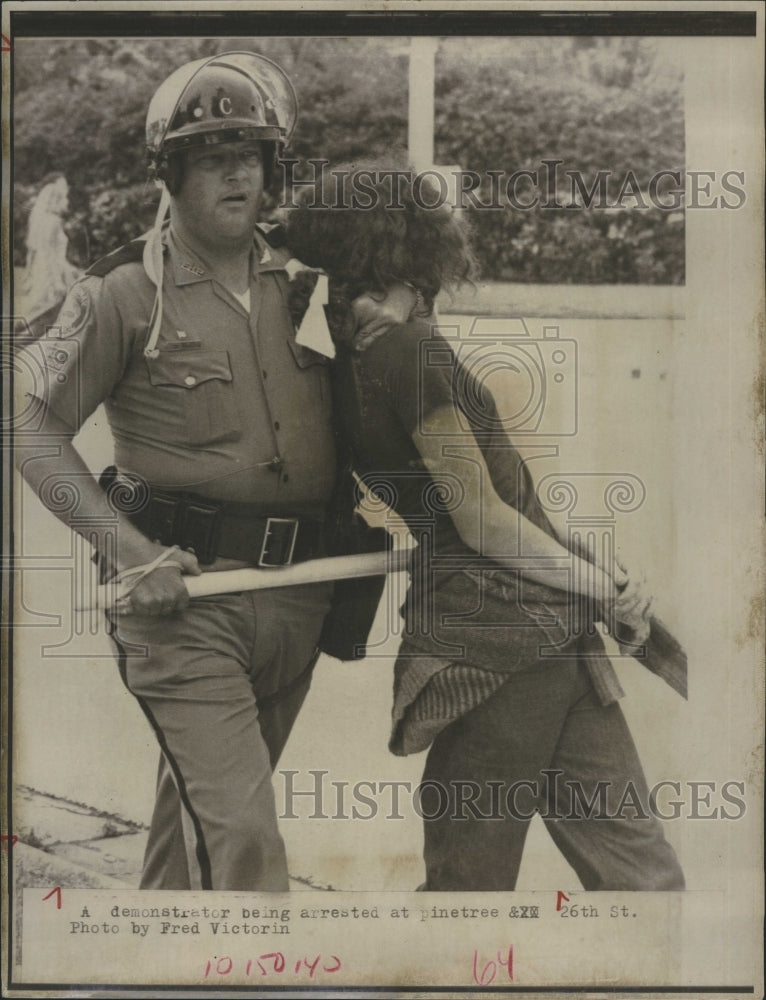 1972 Policeman pokes nightstick into protester. - Historic Images