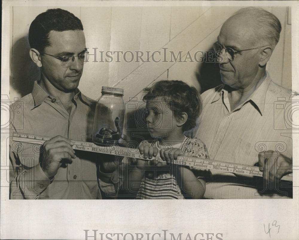 1950 Men and child observe a coral snake in a jar - Historic Images