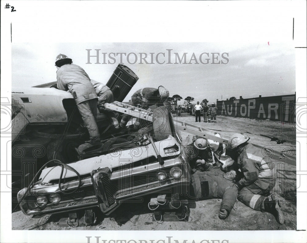 1987 Firefighters training to remove accident victims from cars - Historic Images