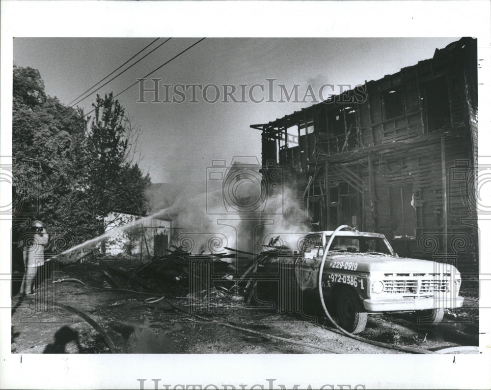 1987 A firefighter extinguishes fire at Tampa apartment - Historic Images