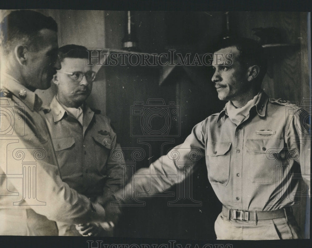 Press Photo  a man shake hands while other man watching them - Historic Images