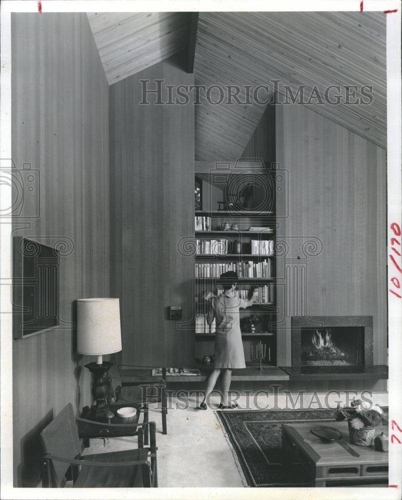 1969 Living room with bookshelf, fireplace and sloping ceilings - Historic Images