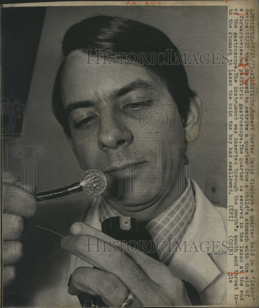 1973 Dr. Robert Davis display a quarter he gets from child stomach - Historic Images