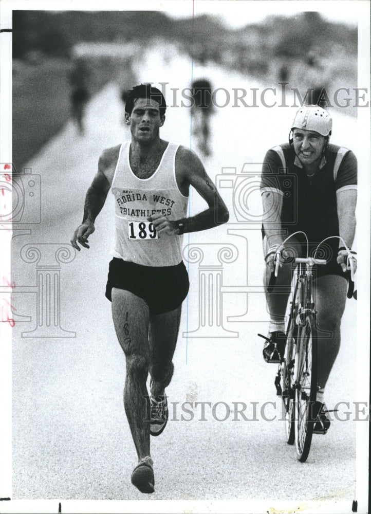 1983 Runner David Denney and Bicyclist Richard Hallick in Triathlon - Historic Images