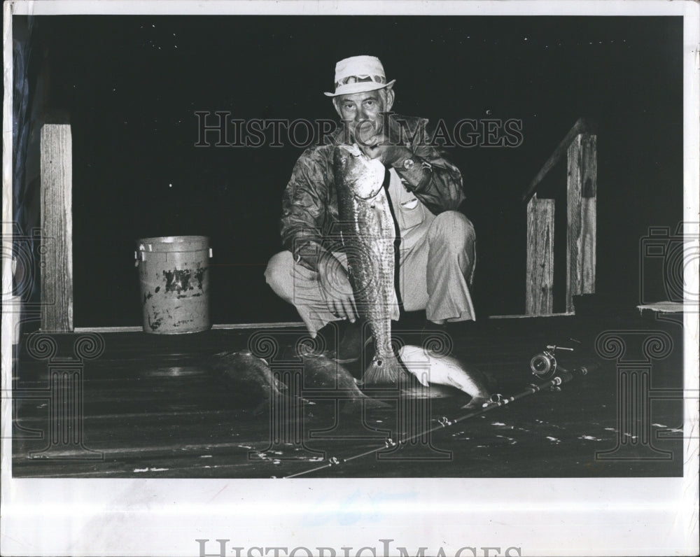 1983 Droesser holds up larger redfish - Historic Images