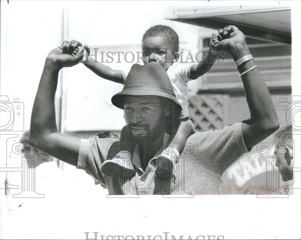 1985 Friendly Man Carries A Boy On His Shoulders - Historic Images