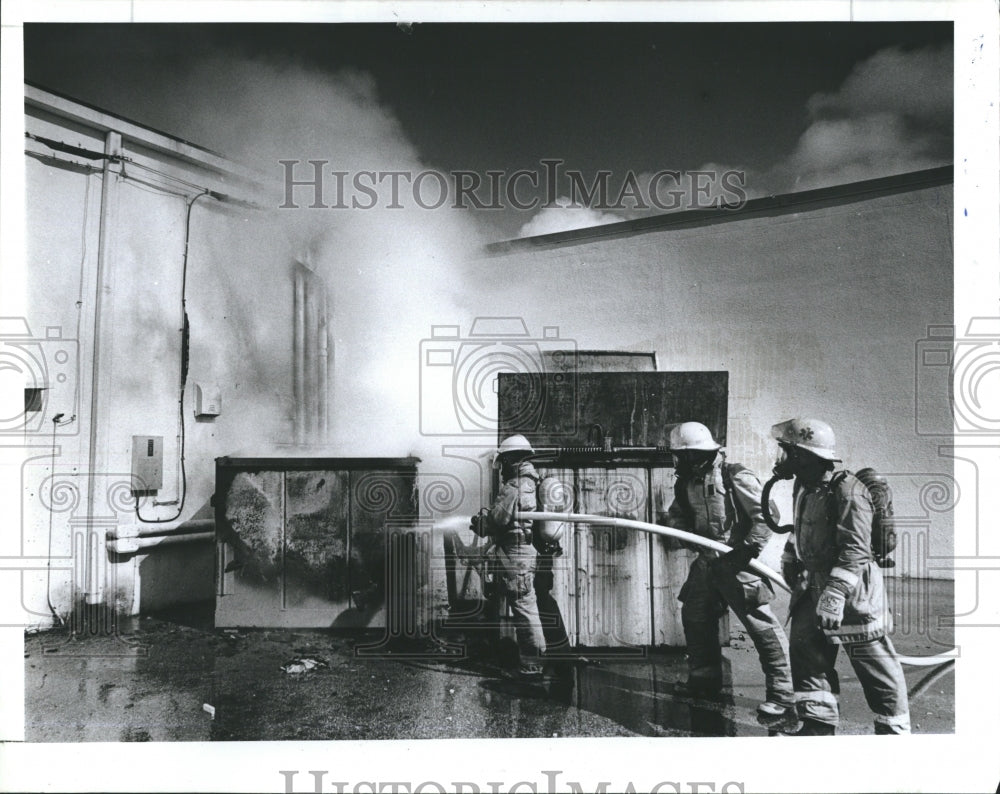 1987 Press Photo St. Petersburg firefighters douse dumpster fire McCrory's Store - Historic Images