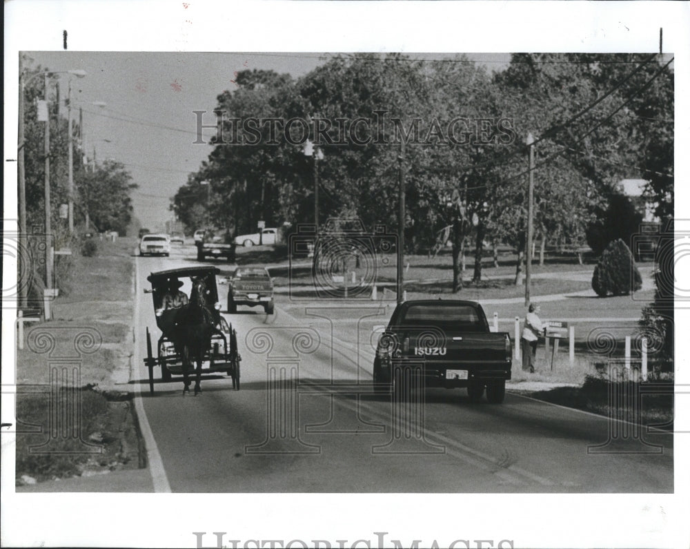 1990 Press Photo John Case in his buggy on St Petersburg street with modern auto - Historic Images