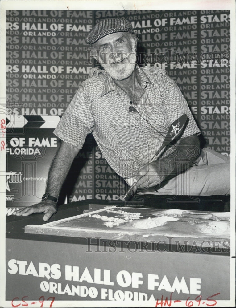 1981 Press Photo Keenan Wynn adds his signature to his footprints &amp; handprints - Historic Images