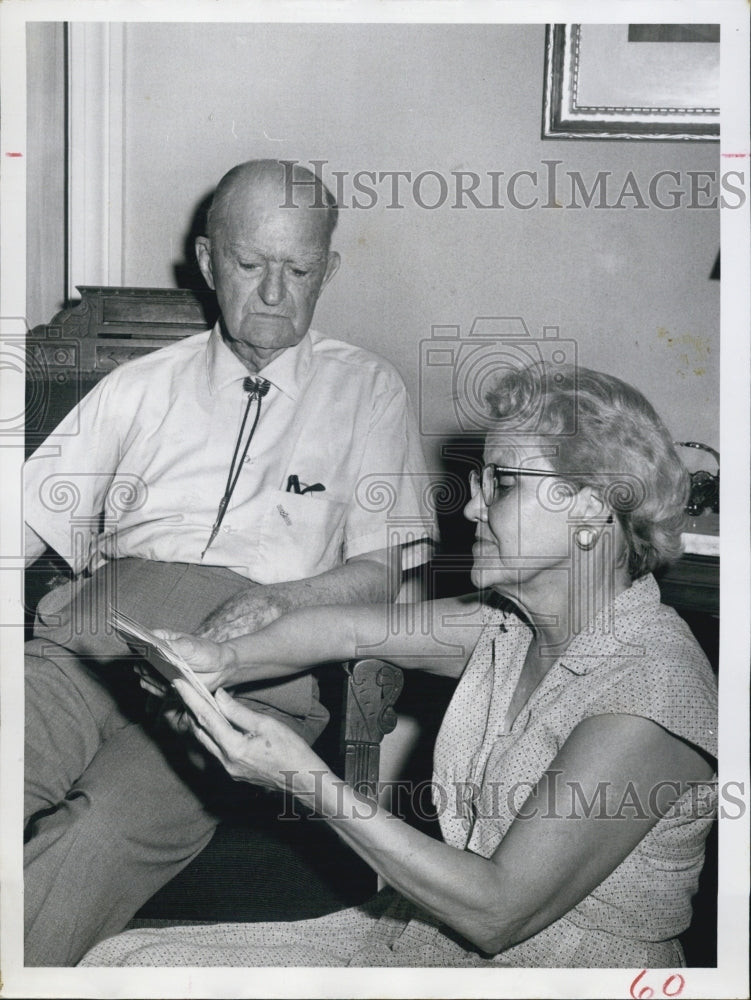 1961 Wesley Haliburton and his niece looking at post cards. - Historic Images