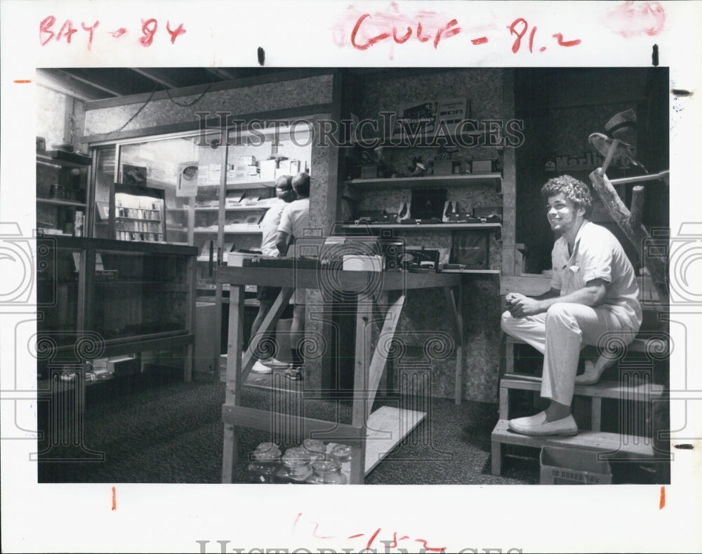 1982 Press Photo Dan Marek with Charley the Parrot help serve the customer. - Historic Images