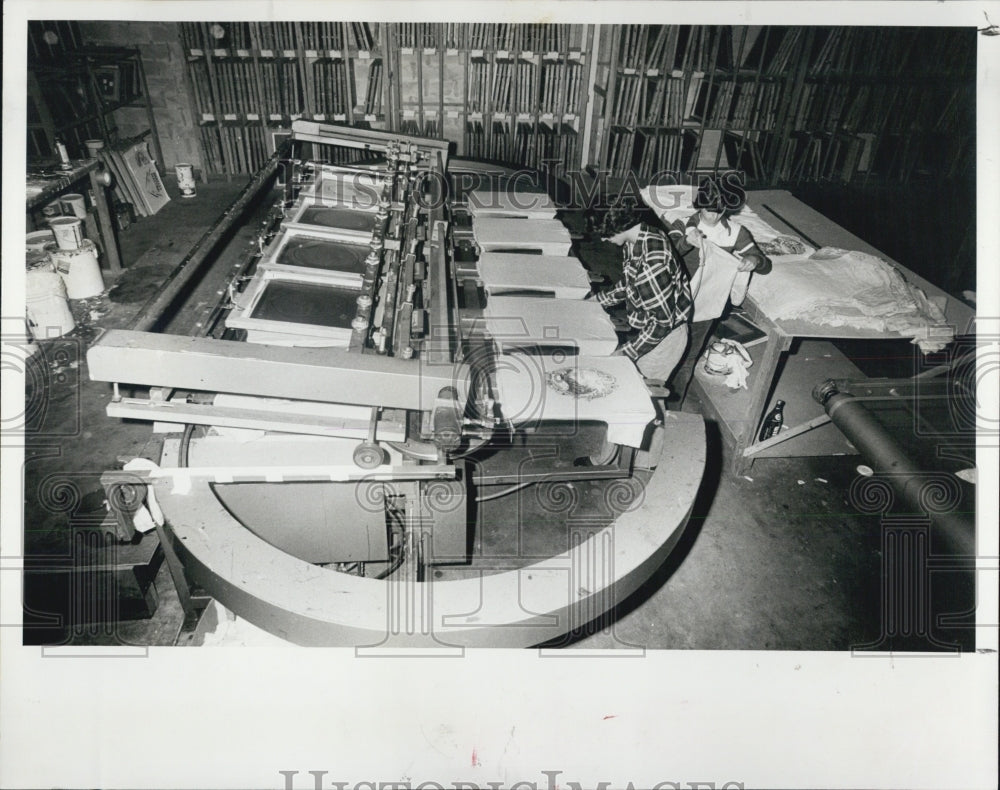 1978 Press Photo Workers Operate Silk Screen Press at Magic Island Shirts Ltd - Historic Images