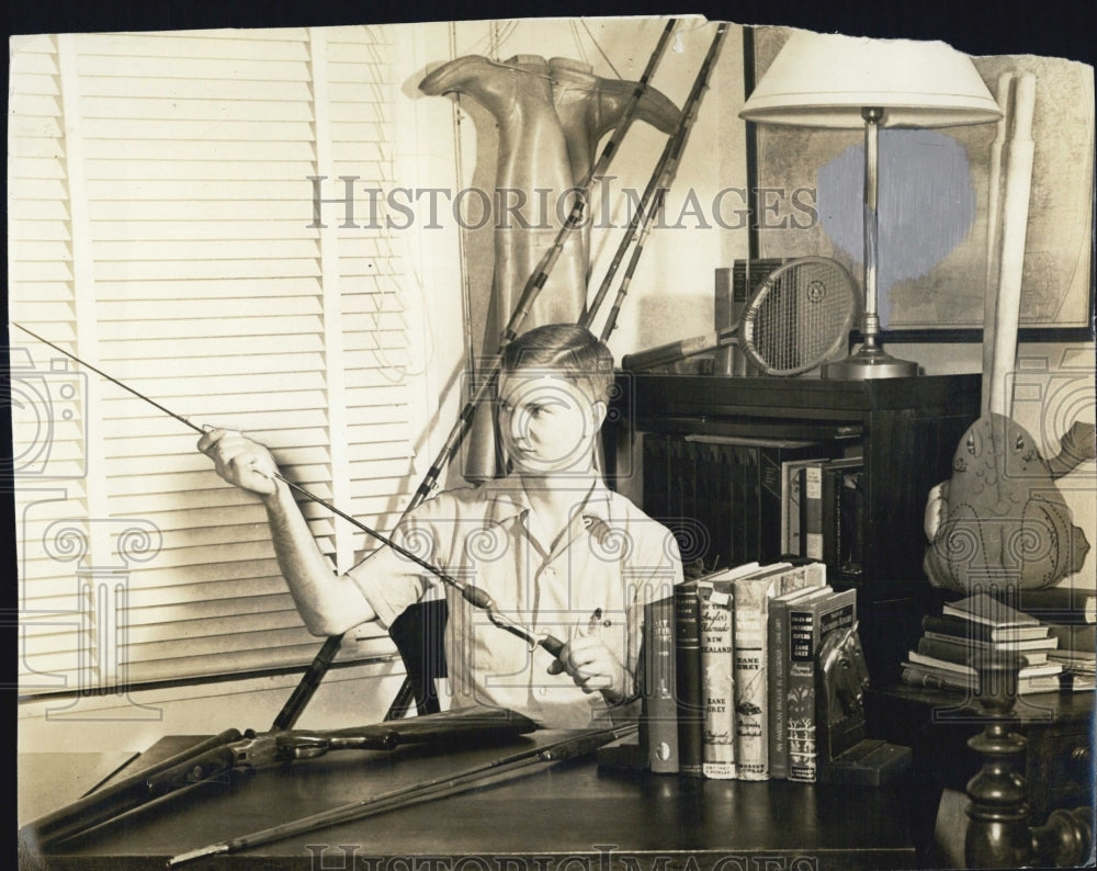 1942 Press Photo Growal M. Marr, fishing poles, gun, WWII era living room - Historic Images